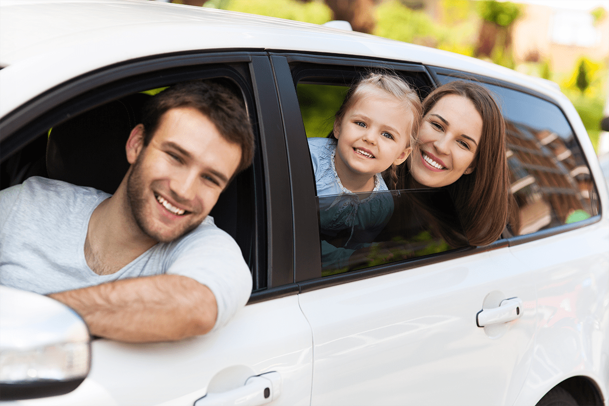 Familie schaut aus den Fenstern eines Autos.
