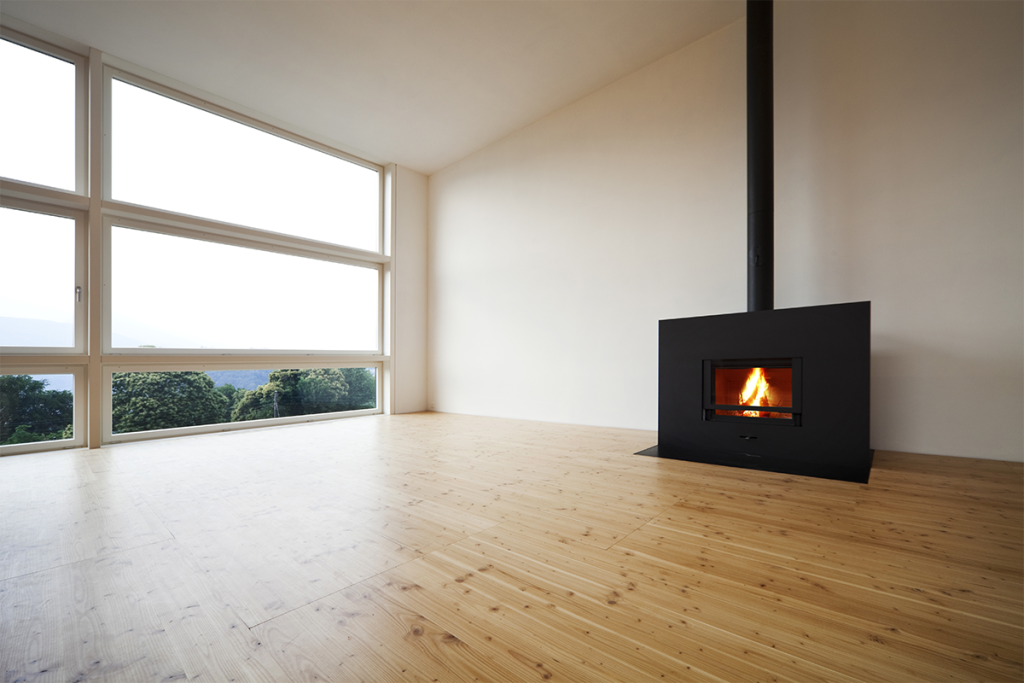 Burning fireplace in a room with floor-to-ceiling windows without other furnishings